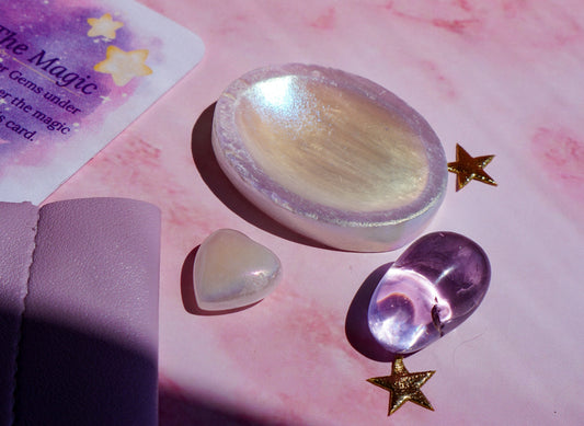Crystals featured in this beginners guide to crystals, including rose quartz, amethyst, and clear quartz on a pink surface