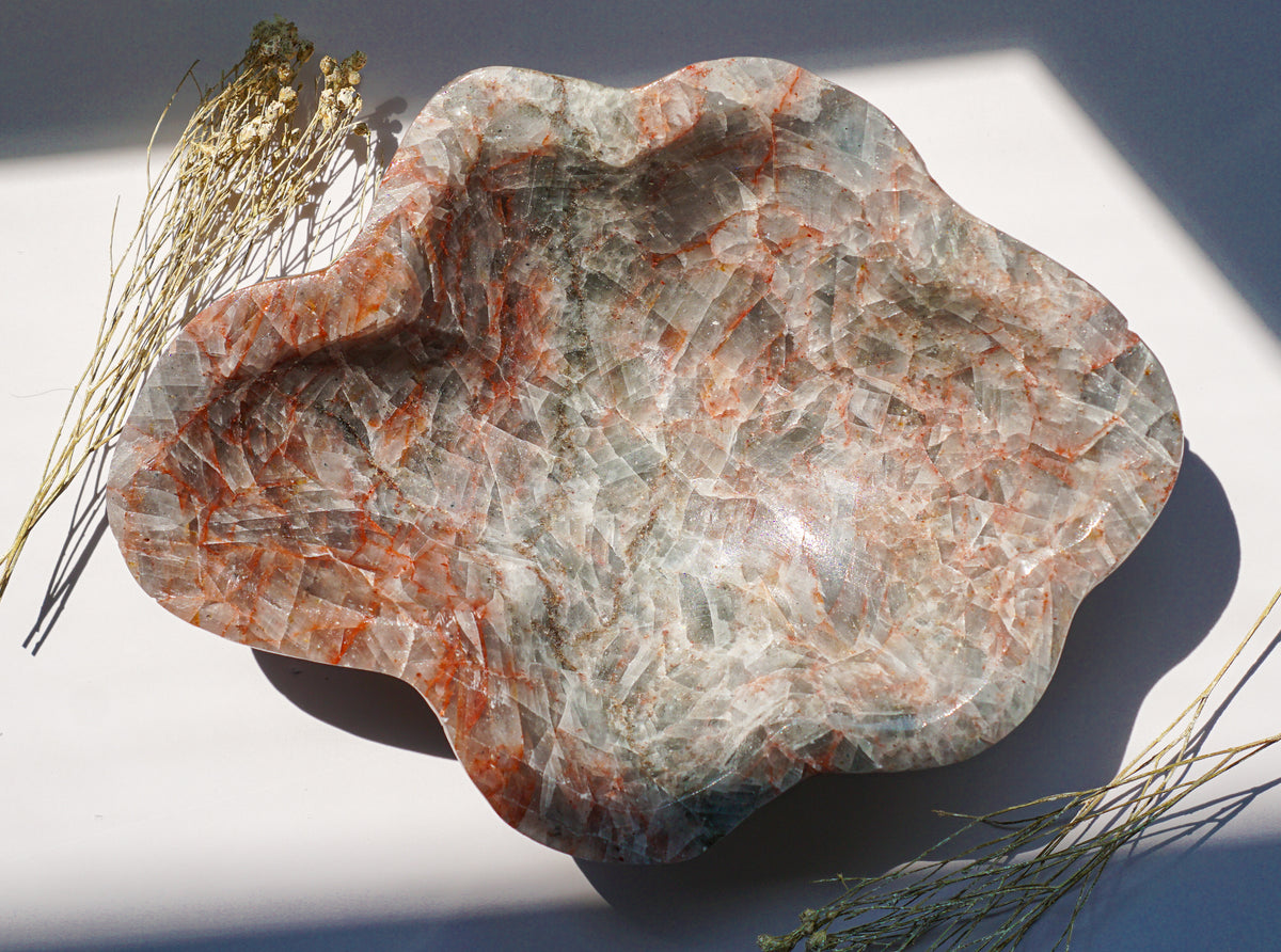 Empty hand carved Blue Calcite bowl showing grey-blue crystalline texture and rust hematite veining