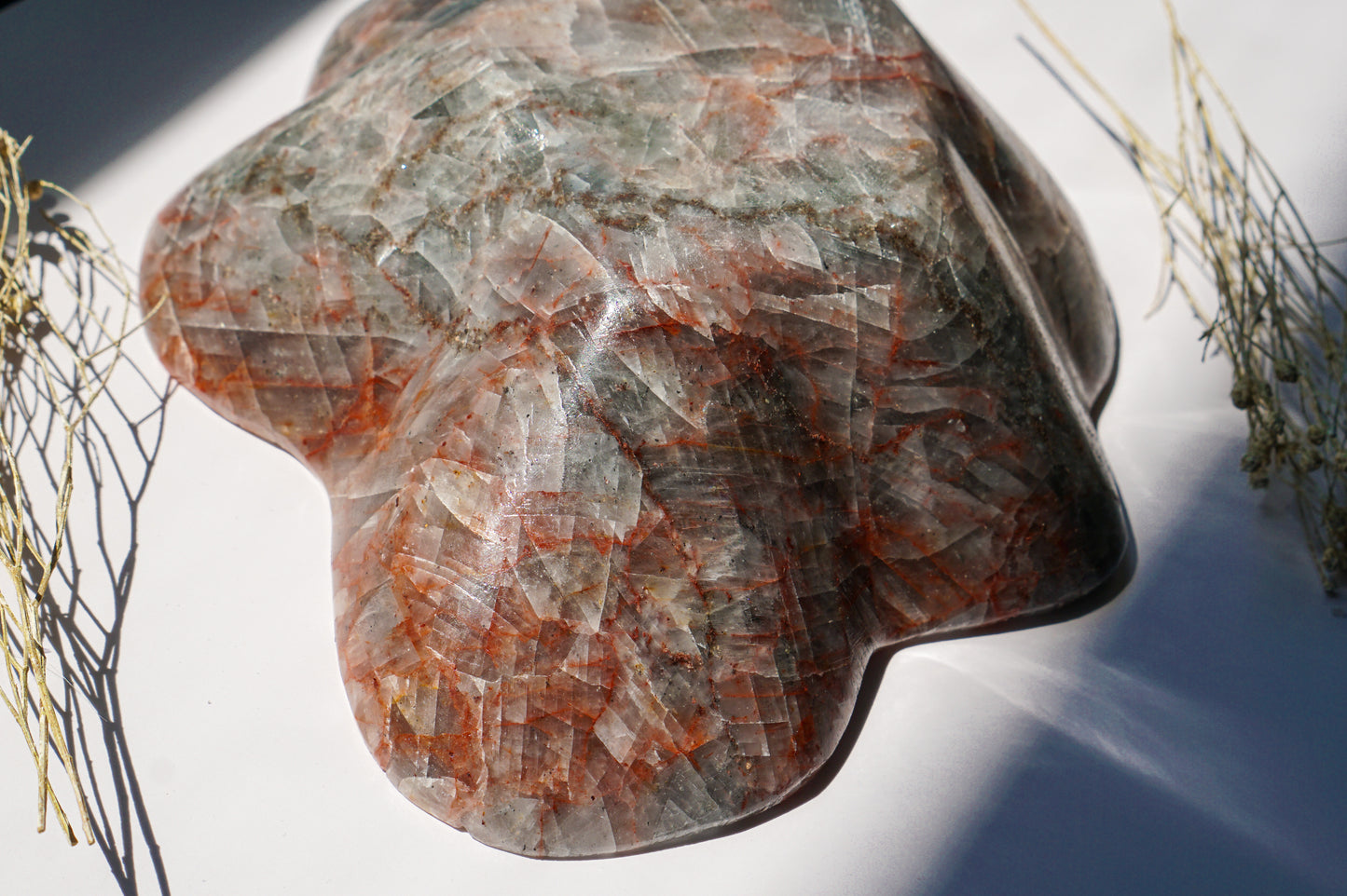 Close-up detail of Blue Calcite hematite bowl exterior showing rust-red hematite veining