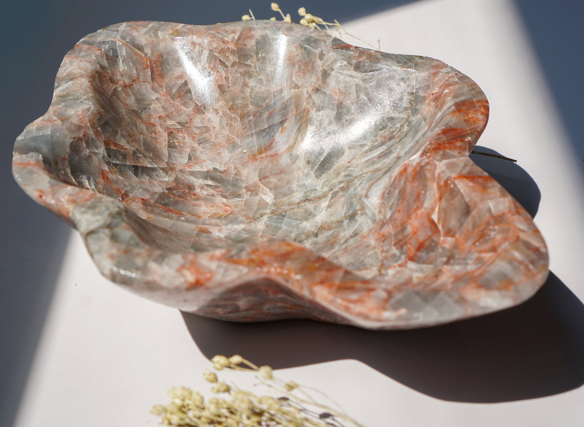Angled view of empty Blue Calcite hematite bowl styled with dried pampas grass