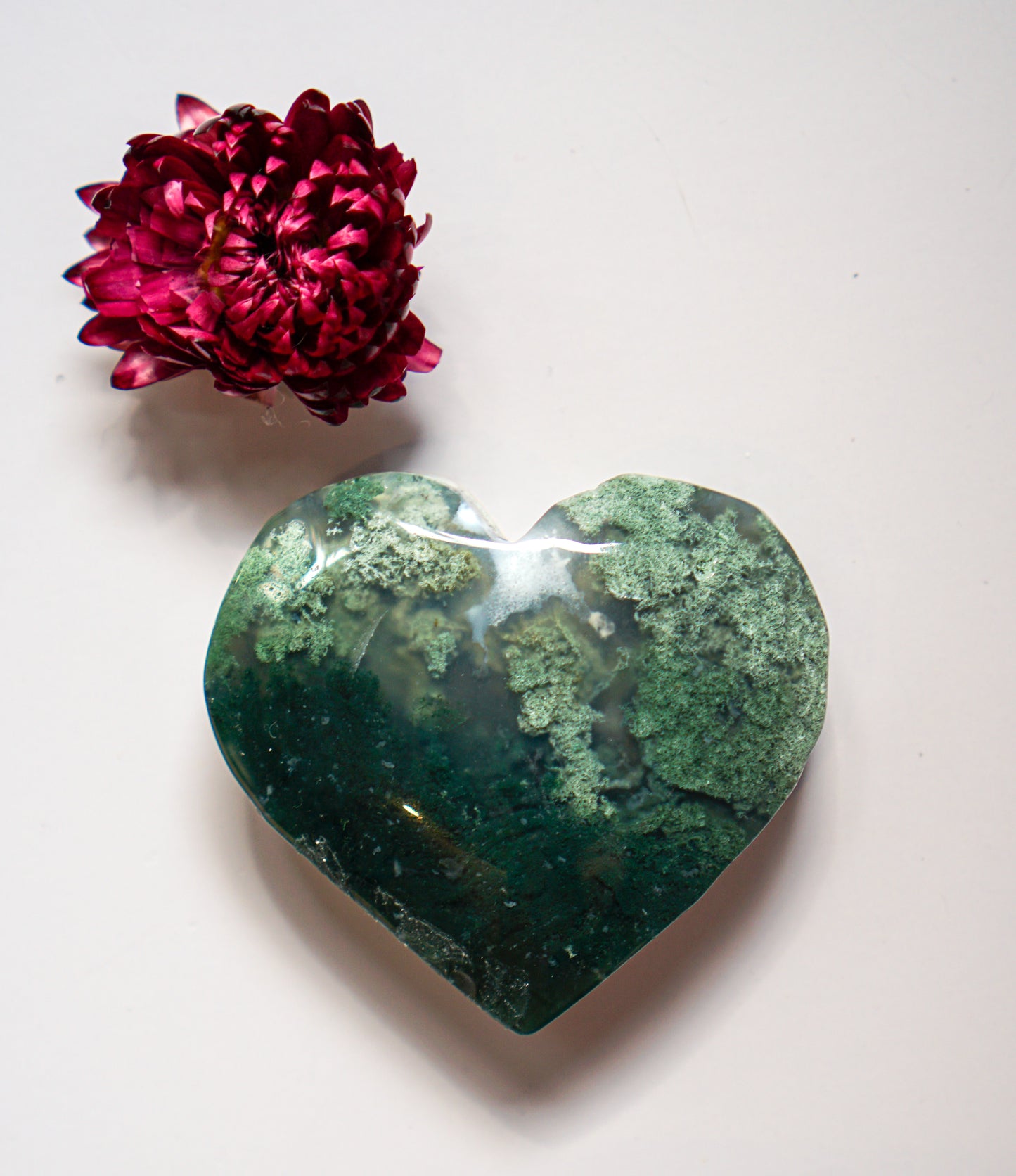 Close-up of a deep forest green moss agate heart showing dense mossy inclusions