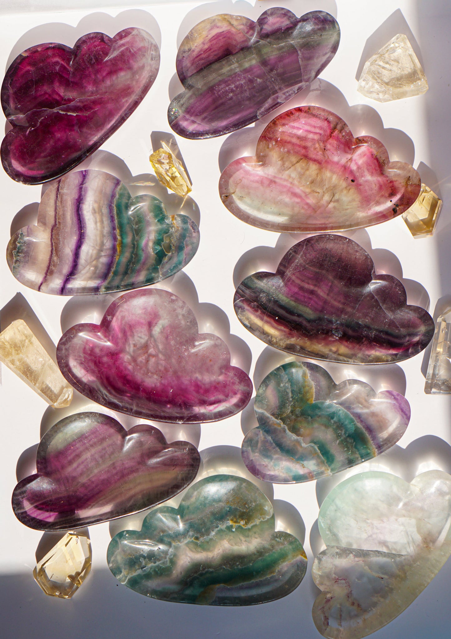 Full set of ten rainbow fluorite cloud dishes styled together in natural sunlight