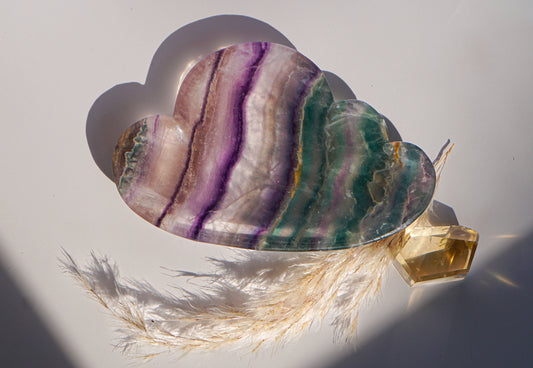 Rainbow fluorite cloud dish in purple and teal rainbow banding with a citrine crystal point and dried pampas grass