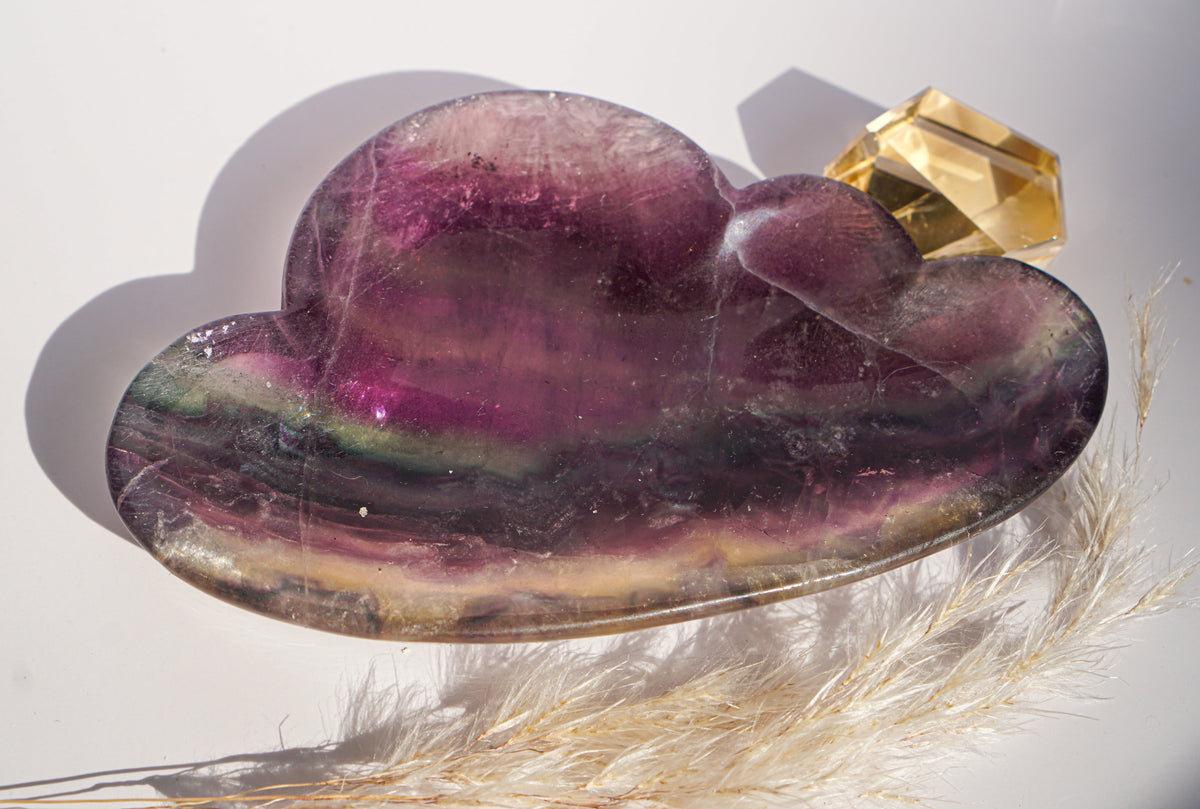 Close-up of rainbow fluorite cloud dish in plum and sage banding