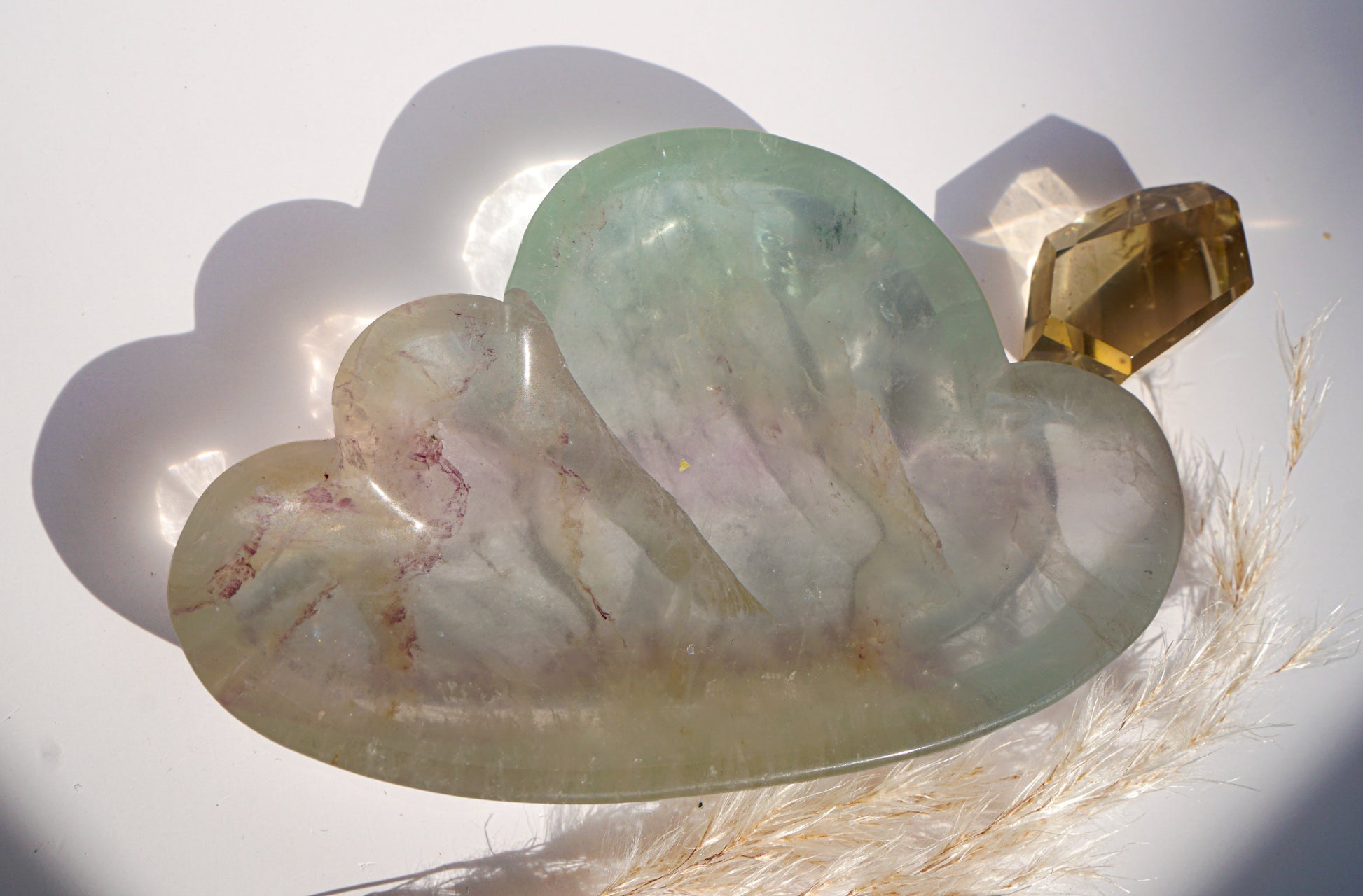 Rainbow fluorite cloud dish in ivory and pink with a citrine crystal point and dried pampas grass