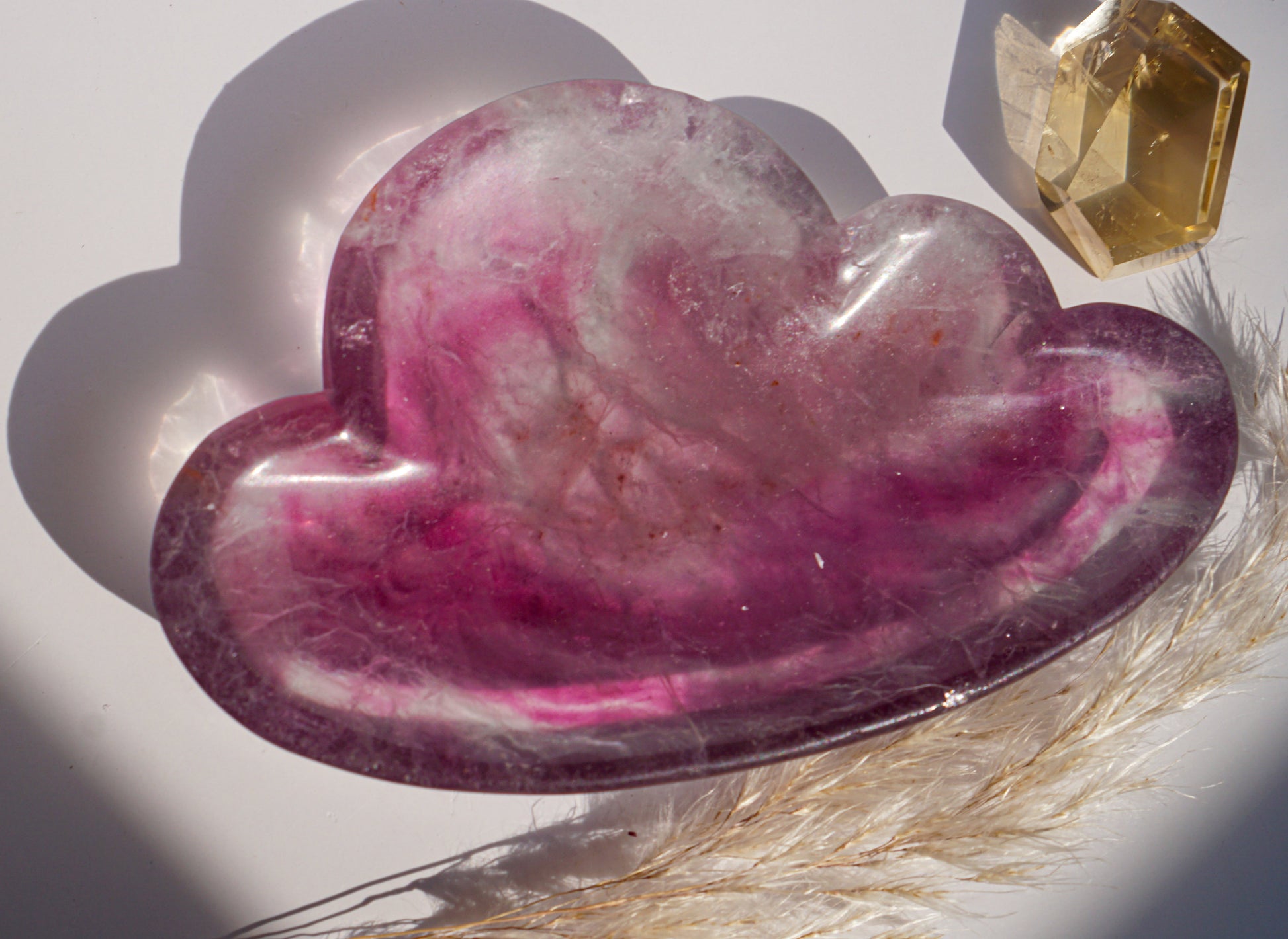 Rainbow fluorite cloud dish in magenta and white with a citrine crystal point and dried pampas grass