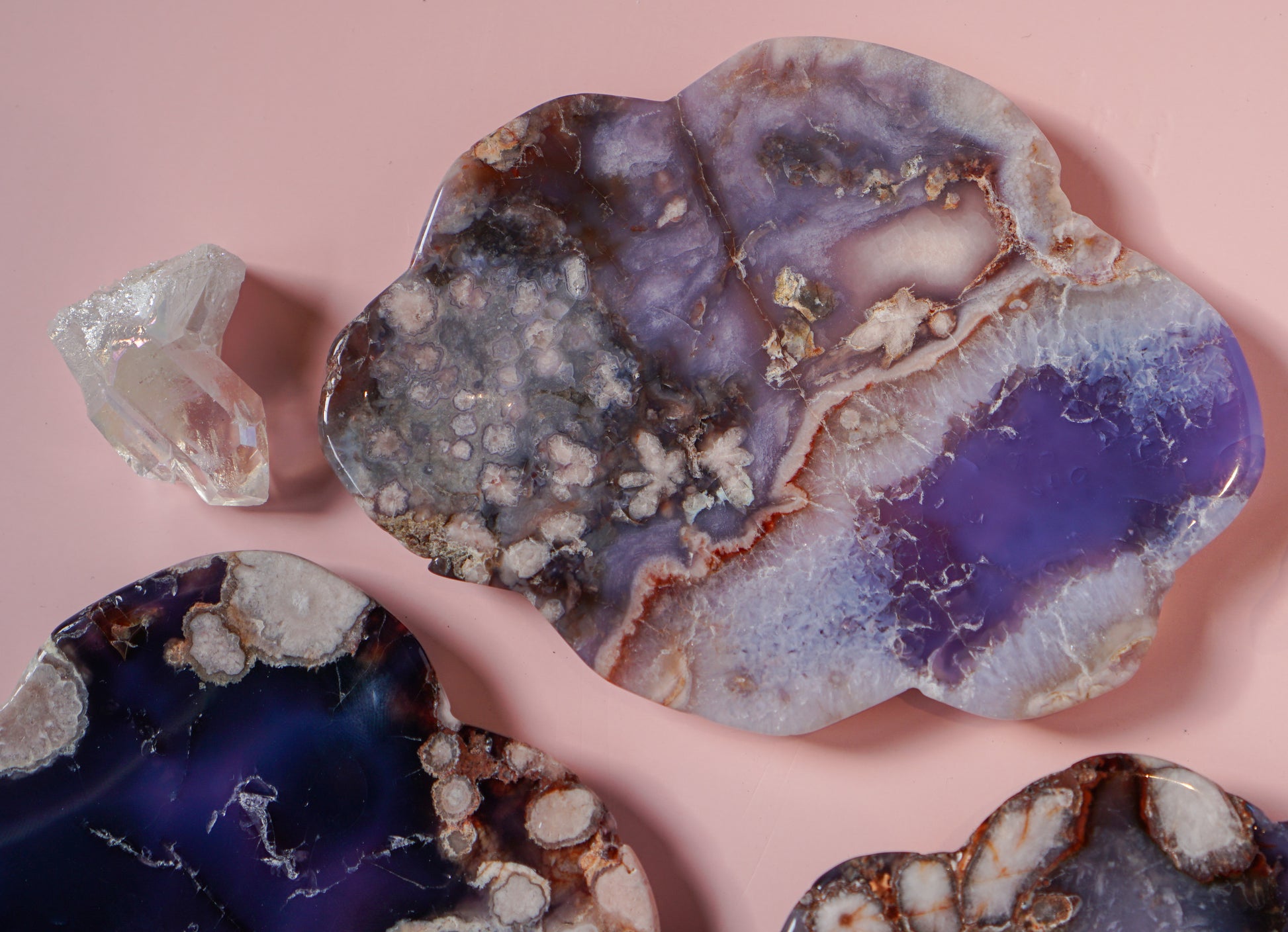 Blue Flower Agate dish with quartz crystal beside it on pink background