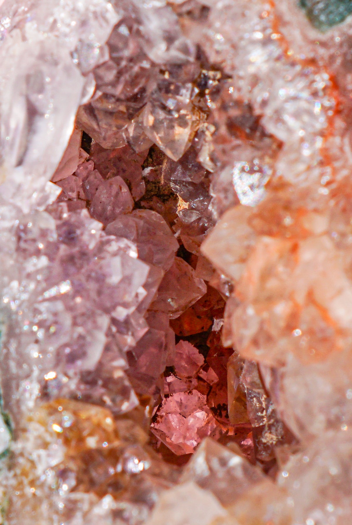 Close-up of a pink amethyst and jasper crystal tower crystal cluster with translucent pink, peach, and reddish-purple crystals surrounded by clear and white crystalline material.